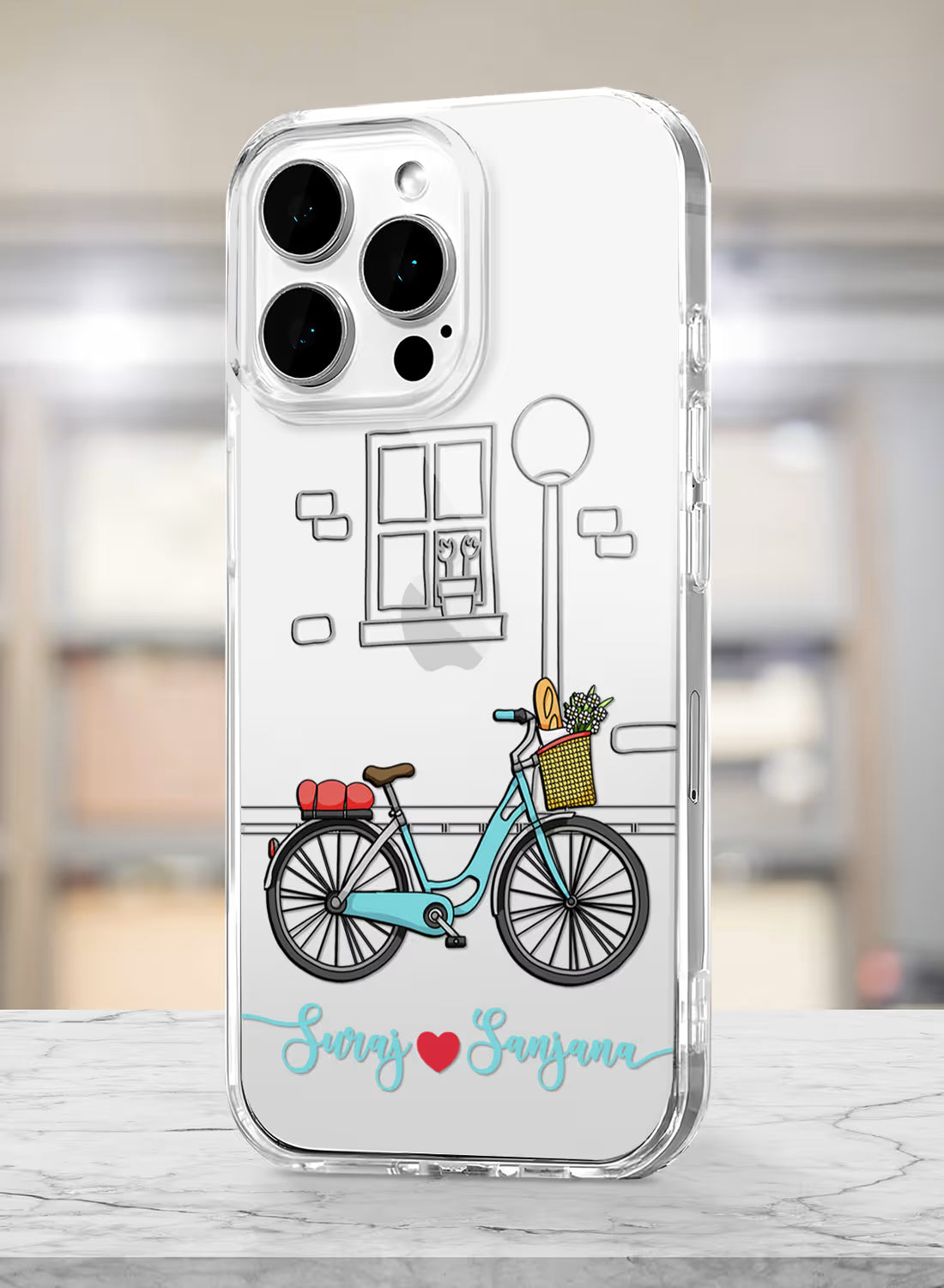 Custom couple names Suraj and Sanjana printed in teal script with a red heart on a clear silicone phone case featuring a vintage bicycle illustration.