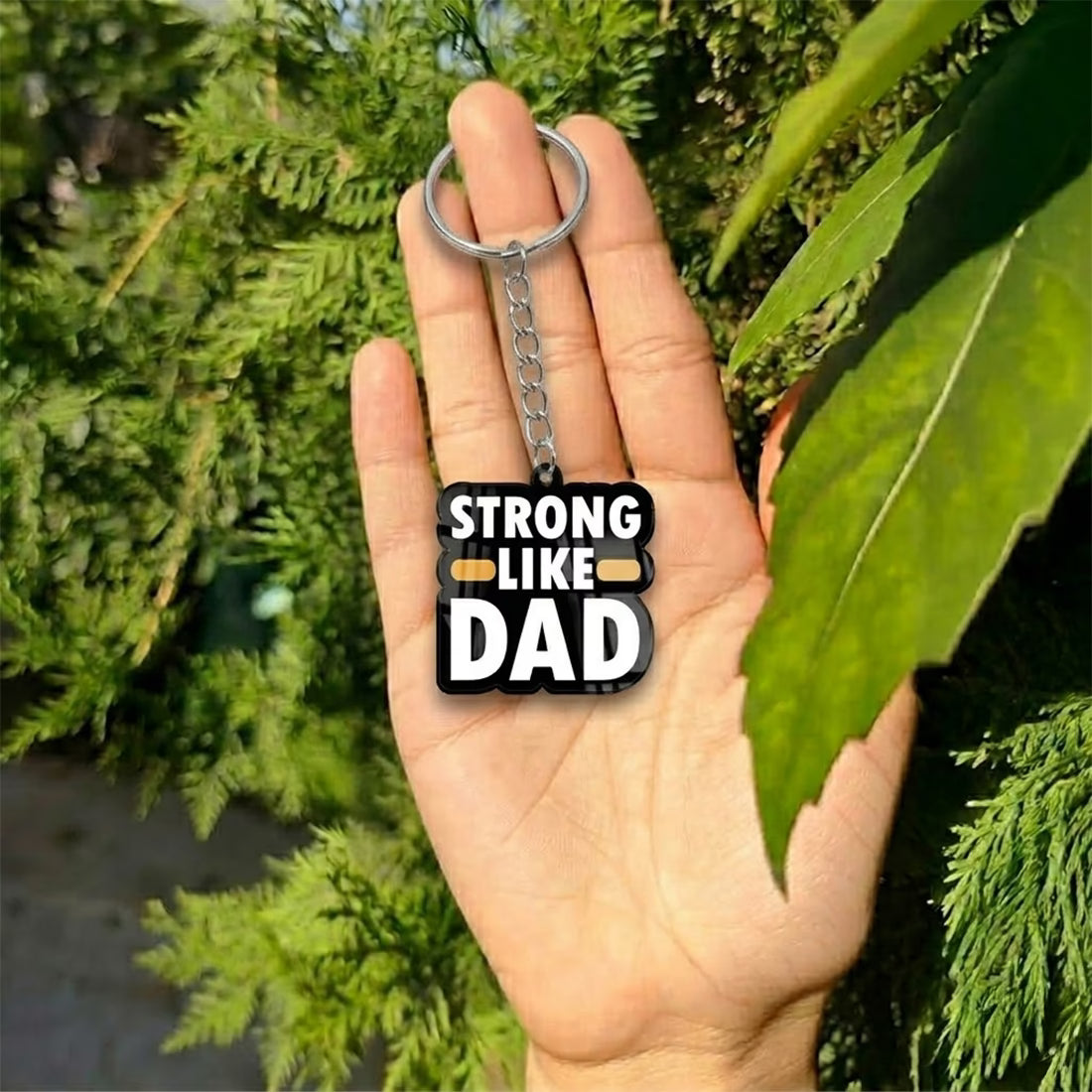 Strong Like Dad acrylic keychain with bold white typography and metal ring
