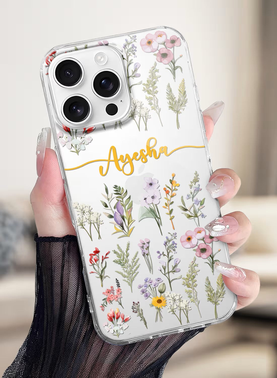 Clear silicone iPhone case featuring a delicate watercolor wildflower design with space for a custom name in gold script.