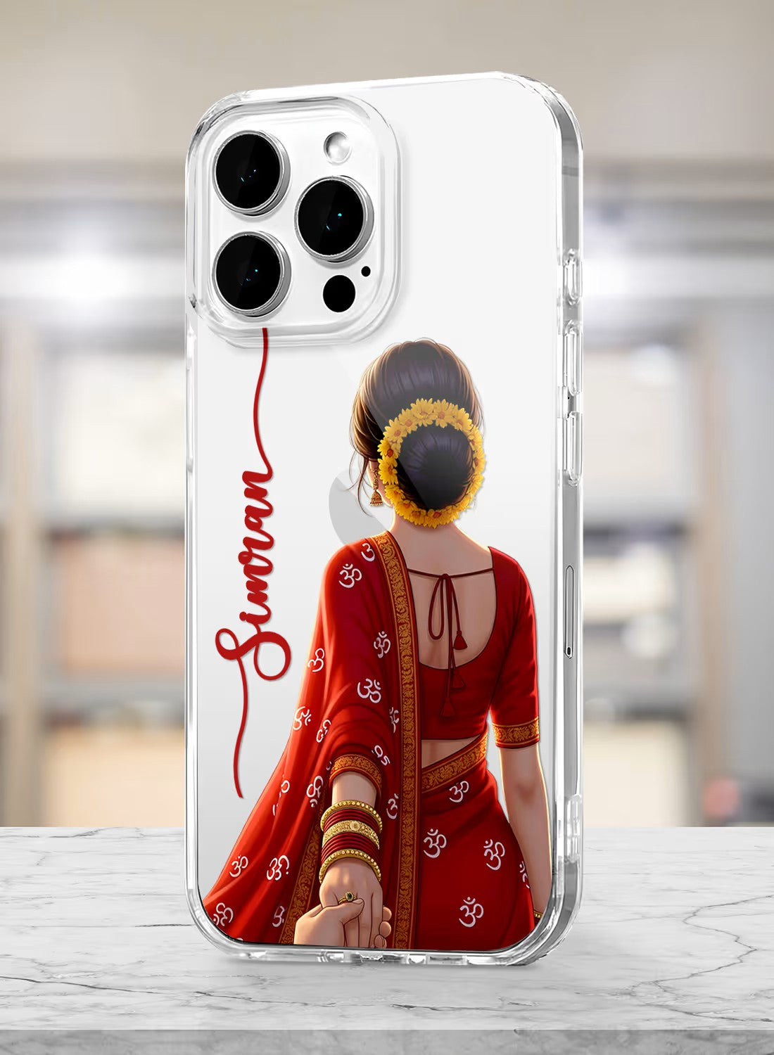 Personalized clear phone case featuring a woman in a traditional red saree with Om symbols and floral bun hairstyle.